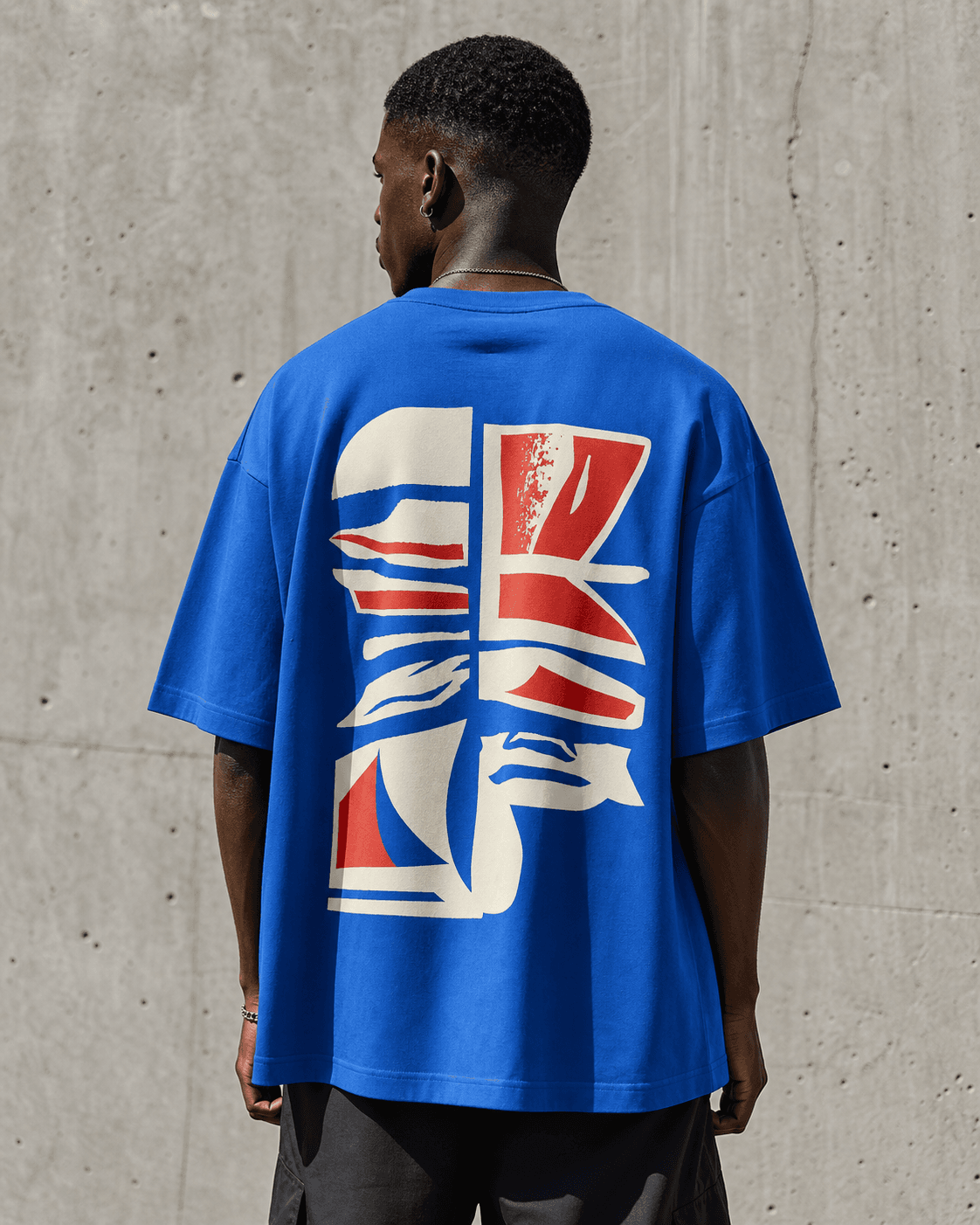 Demo model showing a large abstract print on the back of a cobalt T-shirt