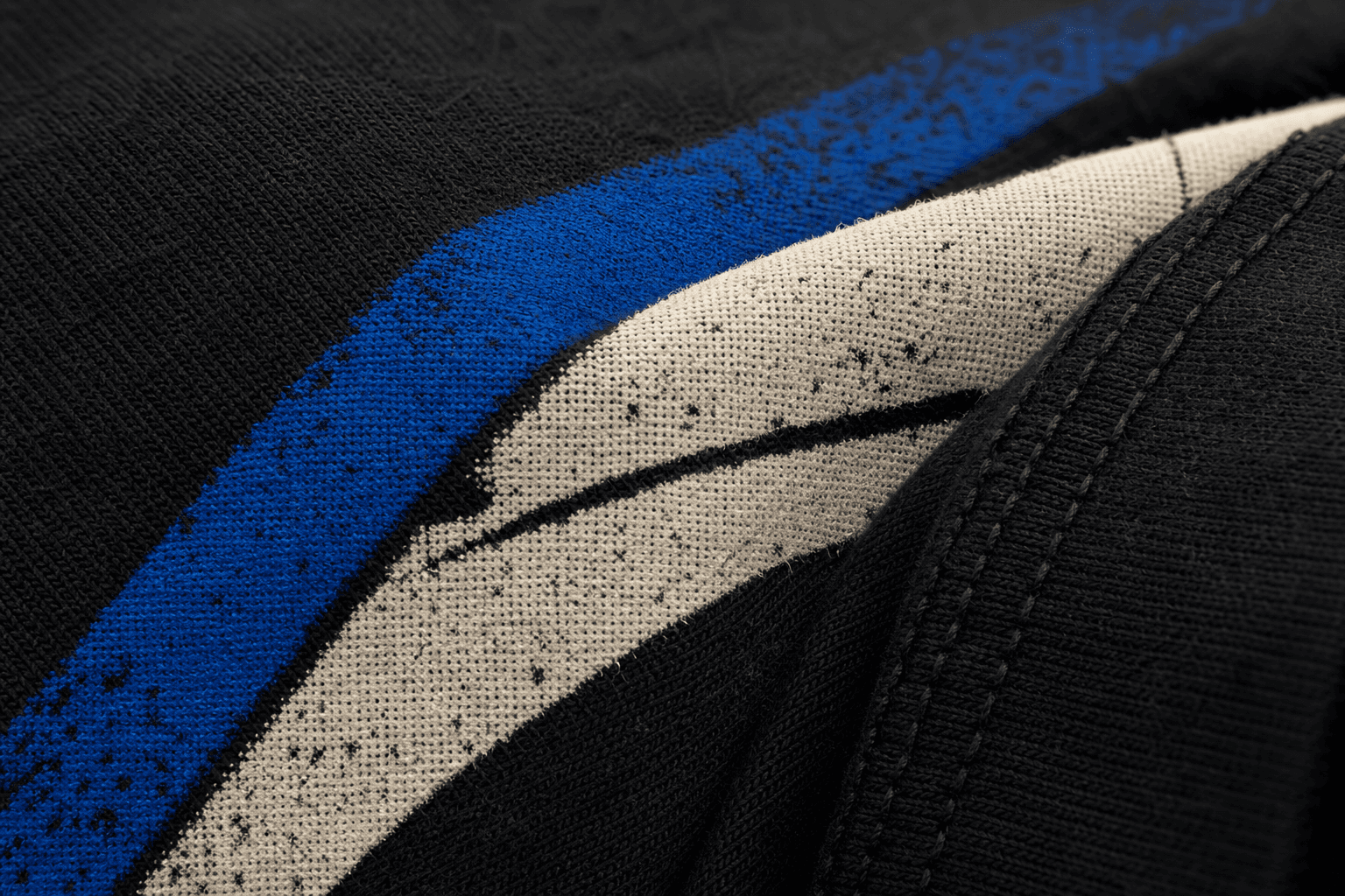 Macro detail of cobalt and bone print ink on black cotton