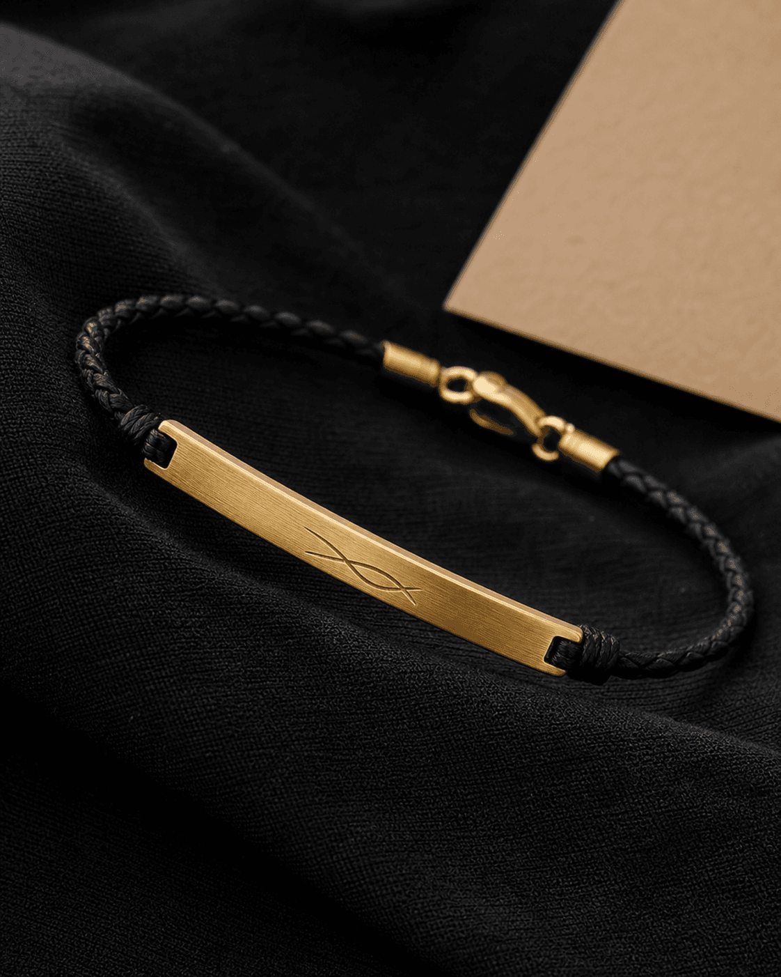 Gold-tone engraved bar bracelet with a black braided cord